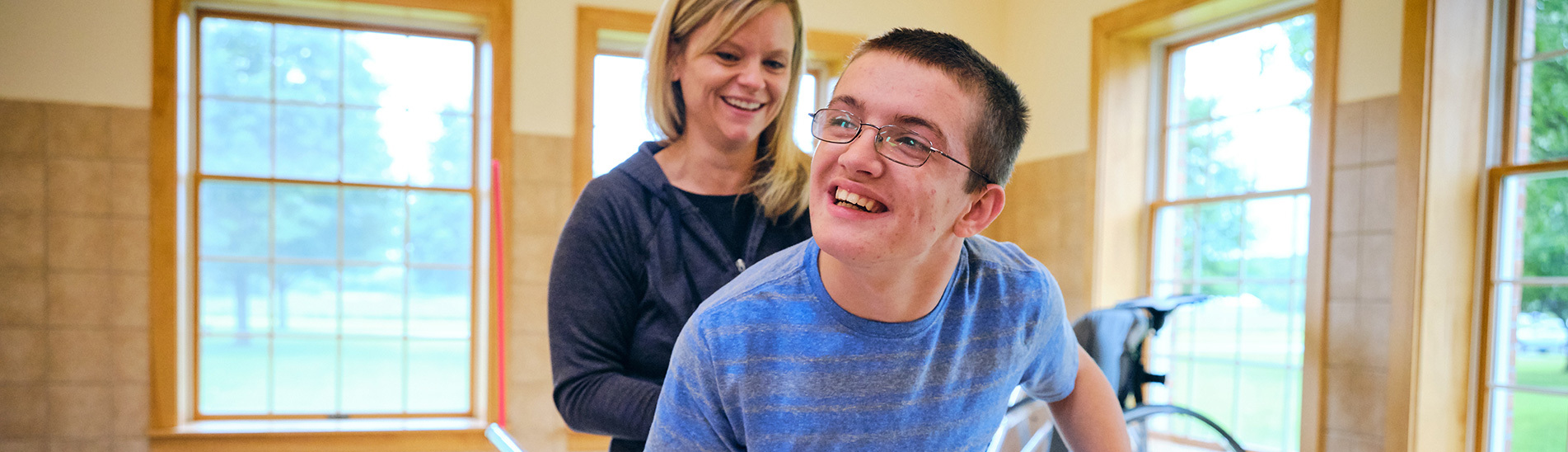 A smiling teacher supports a student with individualized education programs.